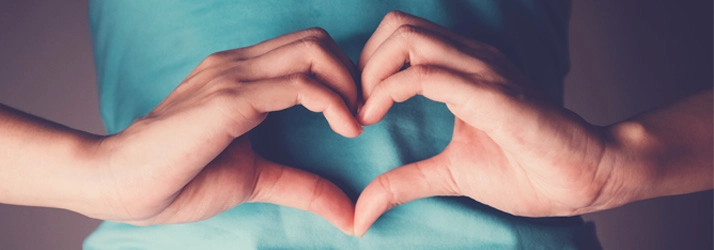 Chiropractic Nashville TN Heart Hands Person forming a heart shape with their hands over their stomach.