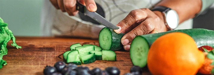 Chiropractic Nashville TN Man Cutting Food Person slicing a cucumber.