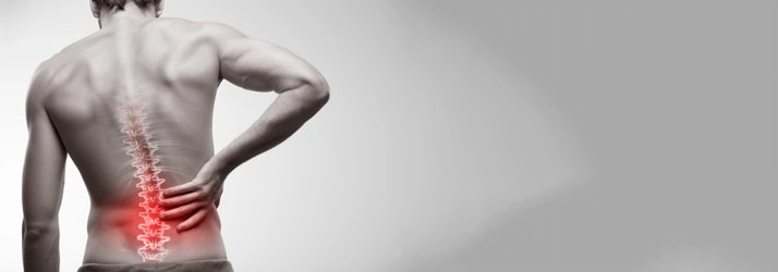 Chiropractic Nashville TN Man With Red Back Pain Man holding his lower back in pain.
